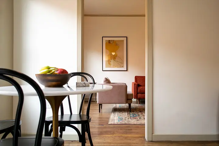 Interior view with fruit bowl and vintage chairs in cozy living area.